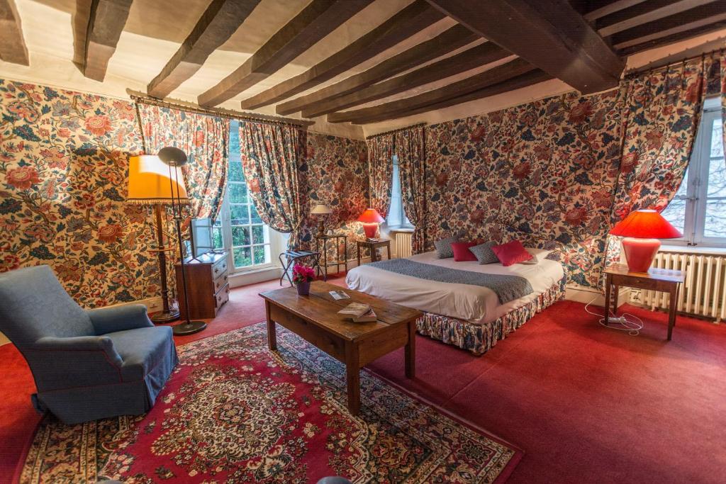 a bedroom with a bed and a couch and a chair at Le Relais Cicero in La Flèche