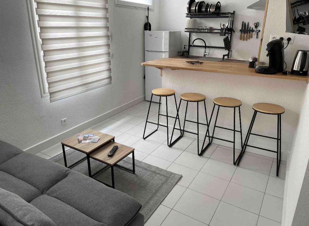 a living room with a couch and a kitchen with stools at StudioC hyper-centre climatisé in Albi