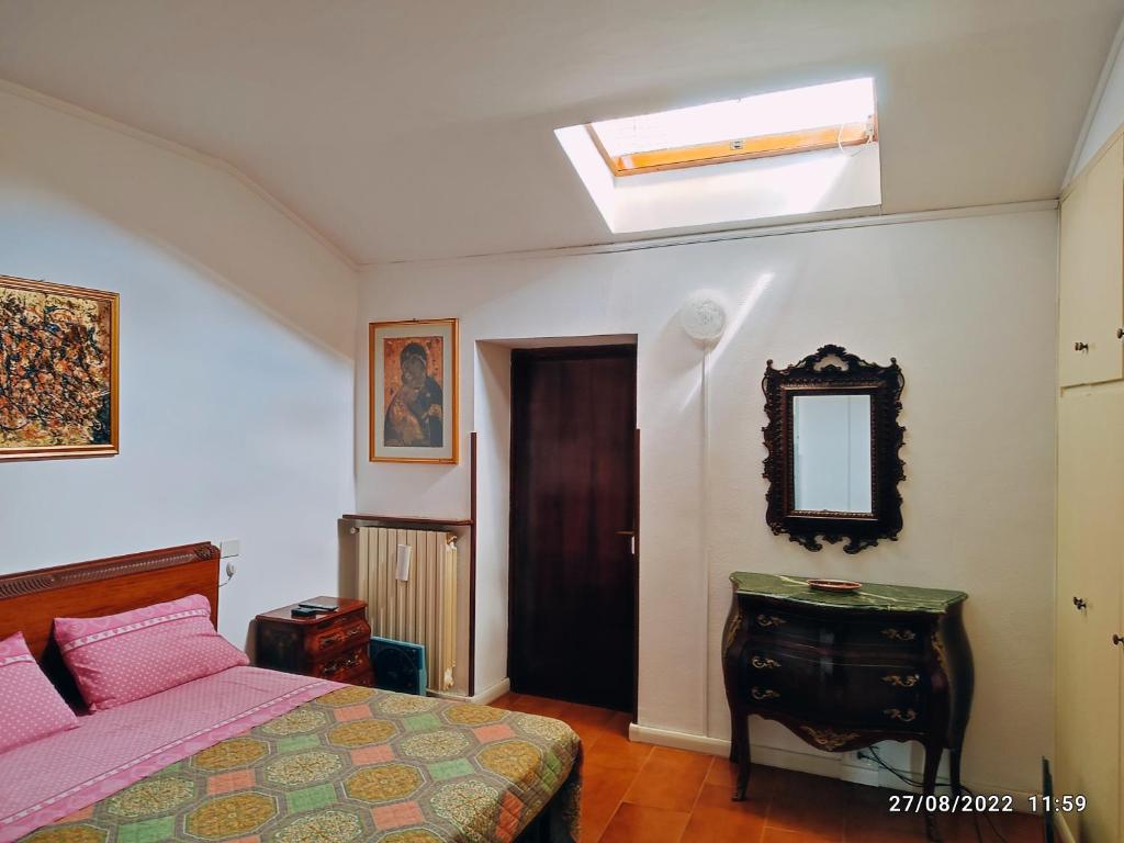 een slaapkamer met een bed, een spiegel en een dakraam bij CasaVacanze Salza nel Borgo in Sutri