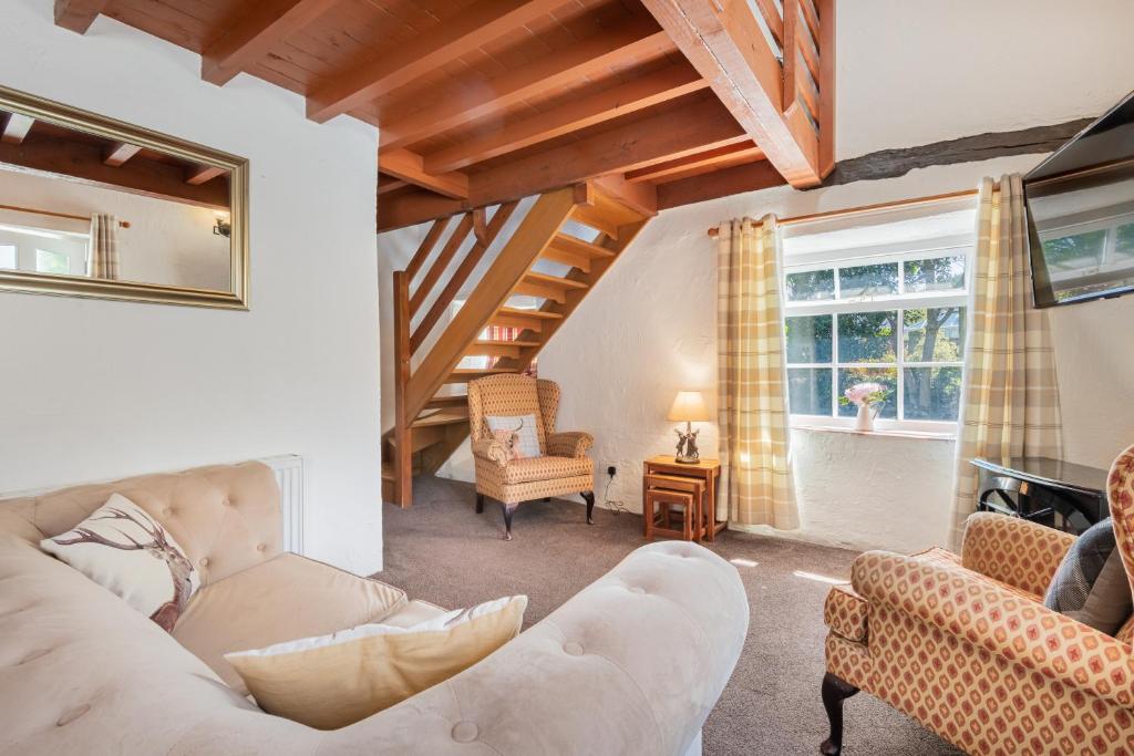 uma sala de estar com um sofá e uma cadeira em Cottage 1, Old Farmhouse Mews em Braithwaite