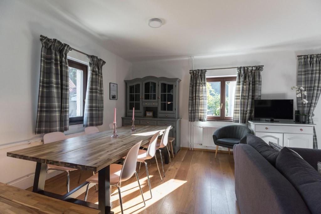 ein Wohnzimmer mit einem Holztisch und Stühlen in der Unterkunft Hiša MIHA Stunning Spacious House & Apartment Podkoren Kranjska Gora in Kranjska Gora