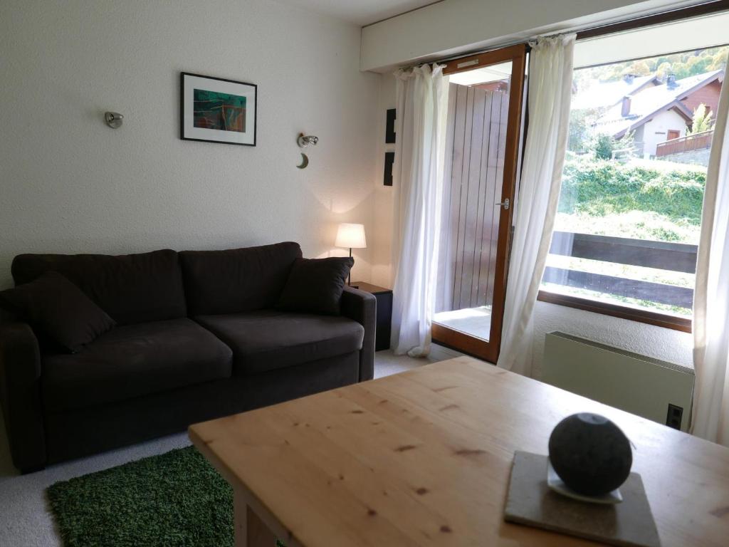 un salon avec un canapé, une table et une fenêtre dans l'établissement Studio cabine 4 pers, balcon, proche pistes et centre, garage sous-sol, tout équipé - FR-1-263-436, à Valloire