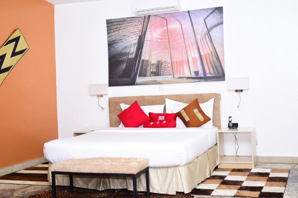 a bedroom with a large bed with red pillows at La Villa Residence Hotel in Kigali