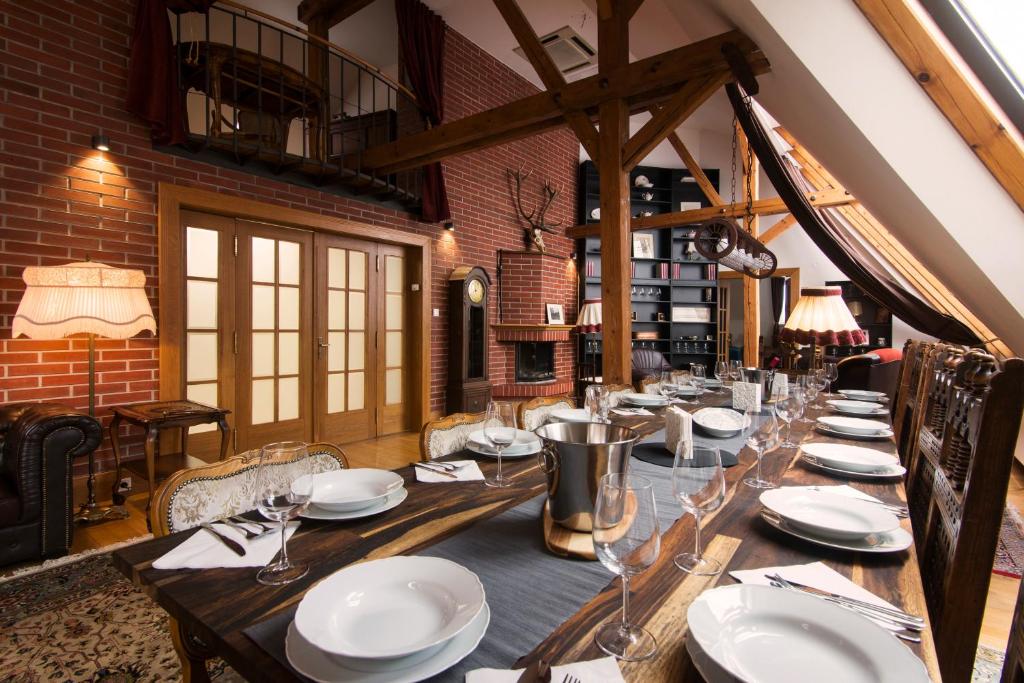 a long wooden table in a restaurant with plates and glasses at Billionaires Club LOFT Sauna City Center in Prague
