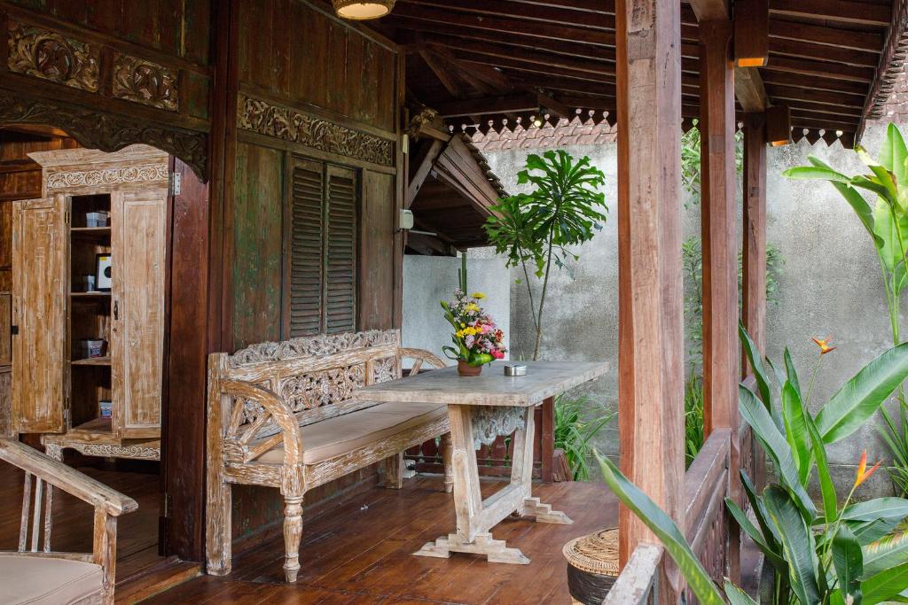un portico con panchina, tavolo e alcune piante di The Meranggi ad Ubud