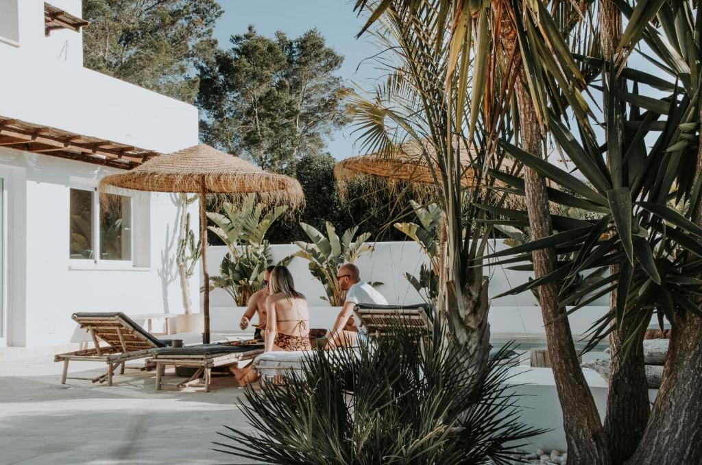 duas pessoas sentadas num pátio num resort em Casa Stellar - boutique villa with private heated pool and sea view - sustainably solar powered em San Jose de sa Talaia
