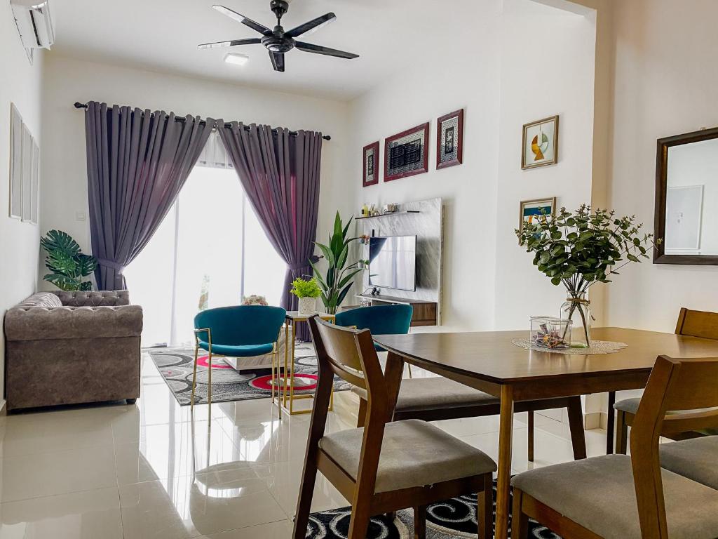 uma sala de jantar e sala de estar com mesa e cadeiras em Tamu Place 3-Bedroom Serviced Apartment with Pool em Kuala Terengganu