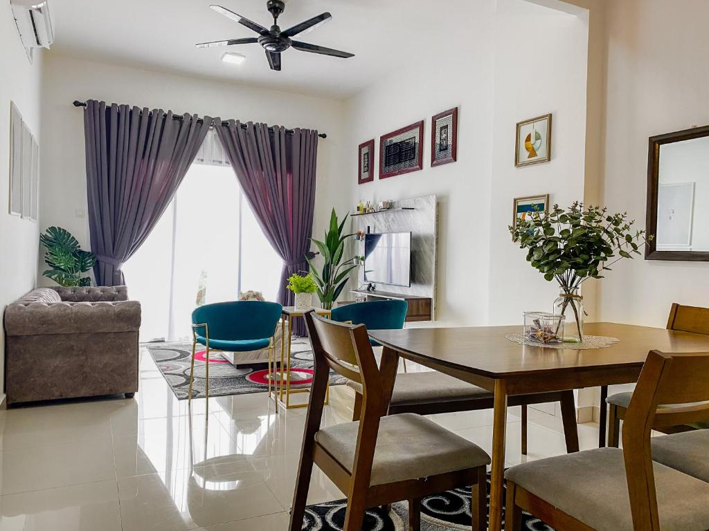 a dining room and living room with a table and chairs at Tamu Place 3-Bedroom Serviced Apartment with Pool in Kuala Terengganu