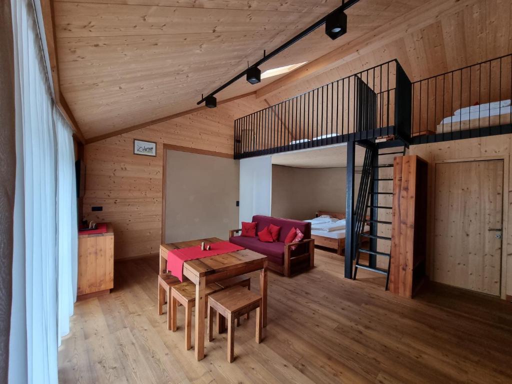 a living room with a table and a loft bed at Bros Hof in Malles Venosta