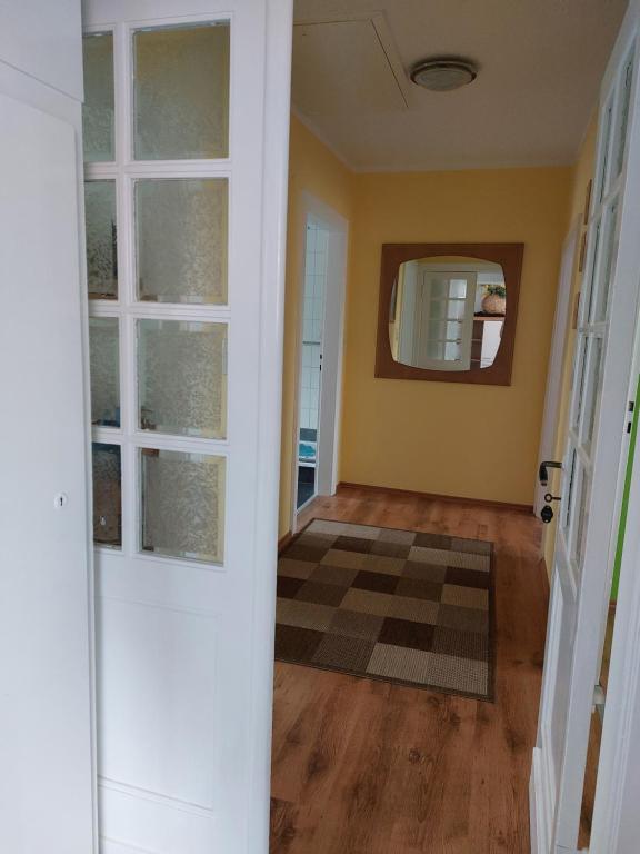 um corredor vazio com uma porta e um espelho em Ferienwohnung Mona Herford em Herford