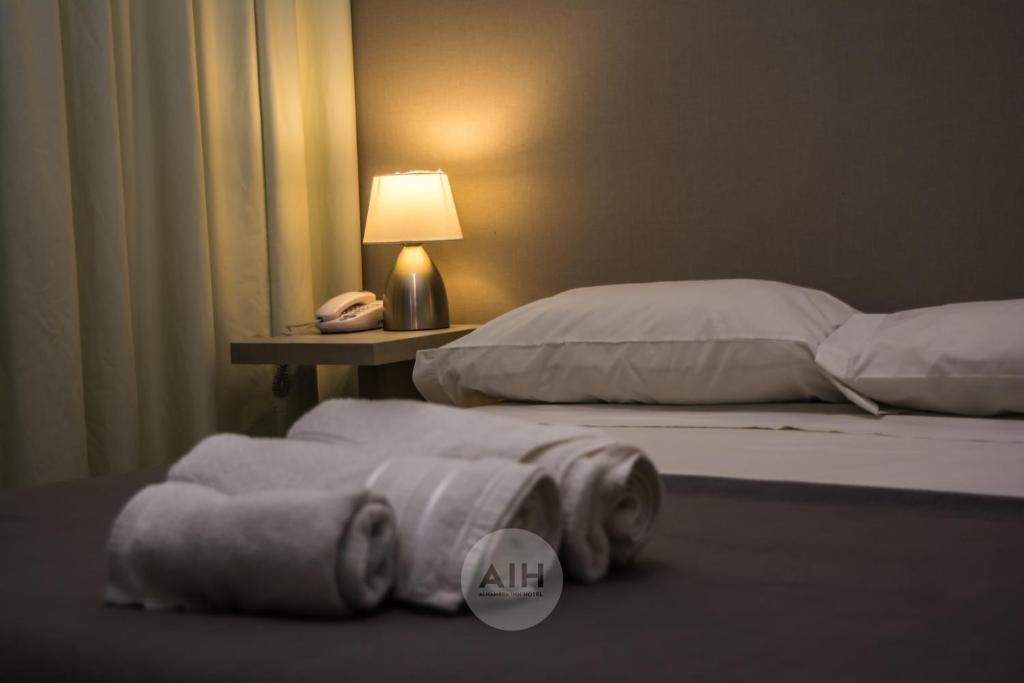 聖胡安的住宿－Hotel Alhambra，一间卧室设有两张床,桌子上配有一部电话