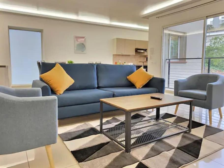 ein Wohnzimmer mit einem blauen Sofa und 2 Stühlen in der Unterkunft CHATENAY 3 in Châtenay-Malabry