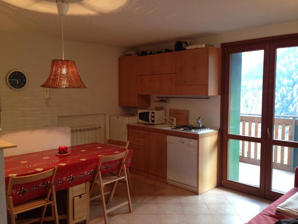 a kitchen with a table with a red table cloth on it at Adamello Ski Appartament in Vione