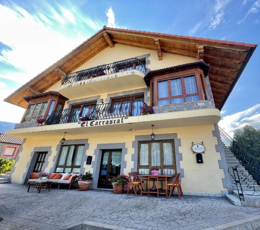 a building with a balcony and tables in front of it at La Casona El Carrascal in La Gandara