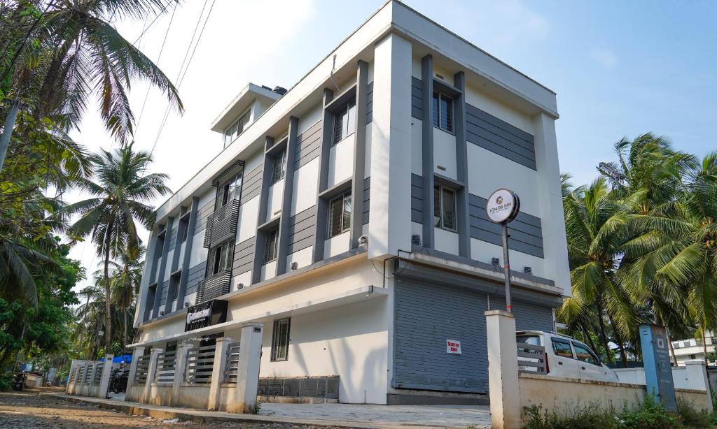 biało-niebieski budynek z palmami w obiekcie Atmos Inn w mieście Kozhikode