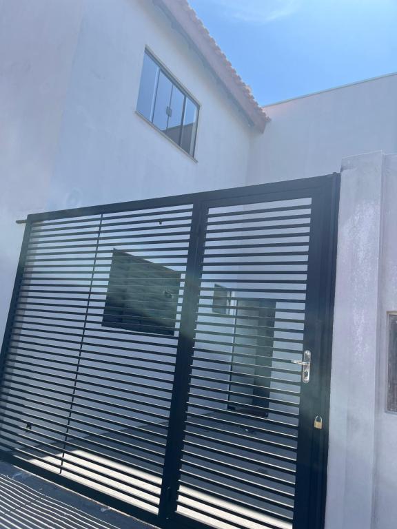a building with a metal garage door with a window at Sobrado Parque Aquático in Andradina