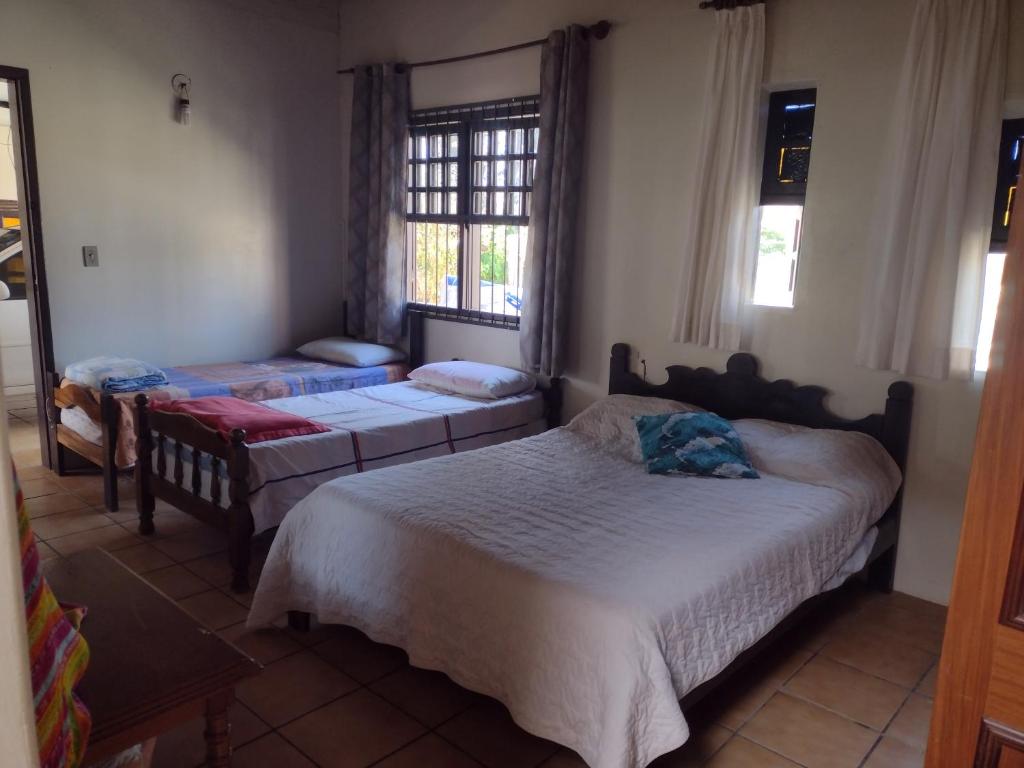 Casa no centro em Garopaba في غاروبابا: غرفة نوم بها سريرين ونافذة
