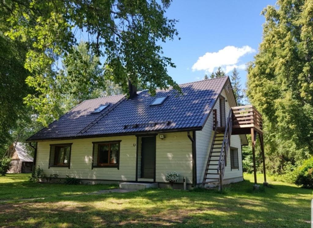 a house with a solar roof on top of it at Väike-Puusmetsa puhkemaja in Valtina