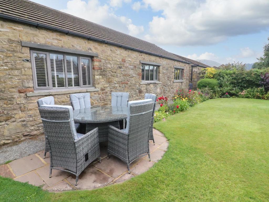 a patio with a table and chairs in a yard at Glen Lea in Settle