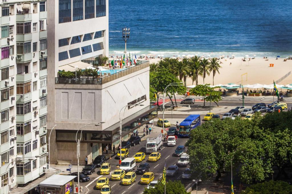 een uitzicht op een drukke straat met auto's en een strand bij Apartamento completo na praia de COPACABANA, 3 SUITES , em andar alto com vista mar, ar ,wifi, tv canais a cabo, pauloangerami MVC18 in Rio de Janeiro