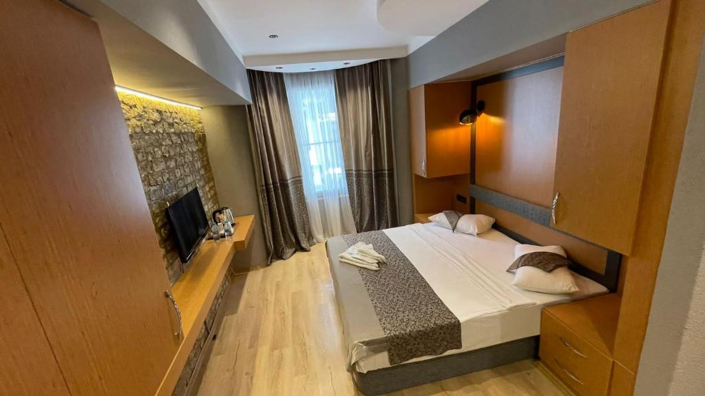 イスタンブールにあるGrand Ambiance Hotelのベッド1台とテレビが備わる小さな客室です。