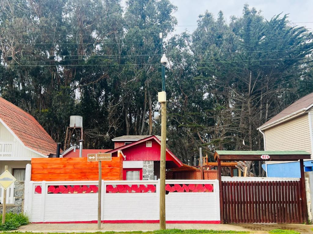 a red and white fence in front of a house at Casa Isla Negra in Isla Negra