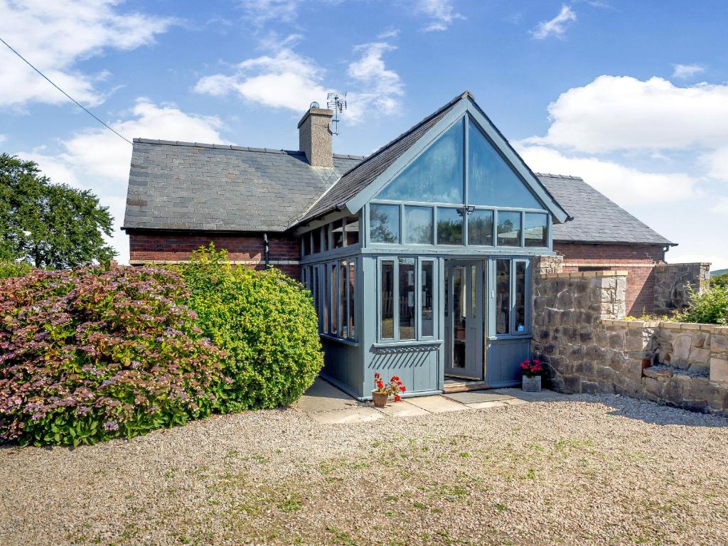 a house with a blue greenhouse in front of it at Tyn Morfa in Pwllheli