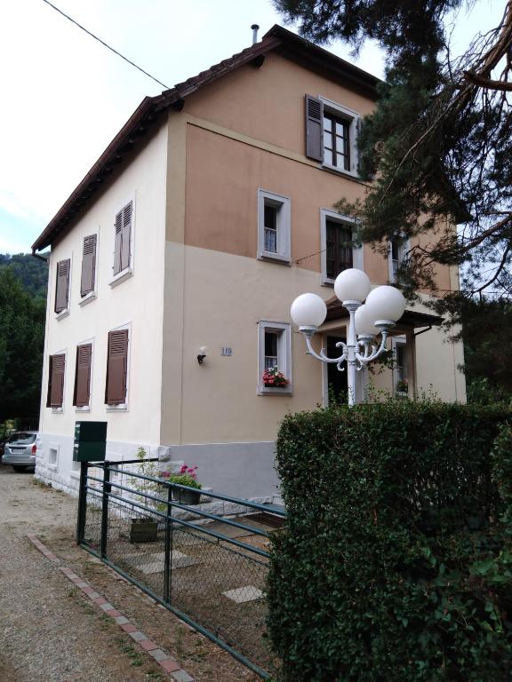 dom z płotem przed nim w obiekcie Appart du 119 w mieście Sainte-Croix-aux-Mines