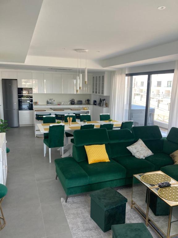 un soggiorno con mobili verdi e una cucina di Luxury Apartment Agnieto - The View Fuengirola a Fuengirola