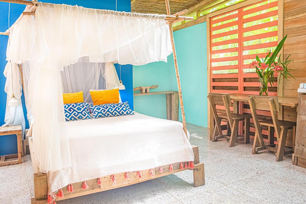 1 dormitorio con 1 cama, mesa y sillas en Bee Happy Studio, en Cahuita