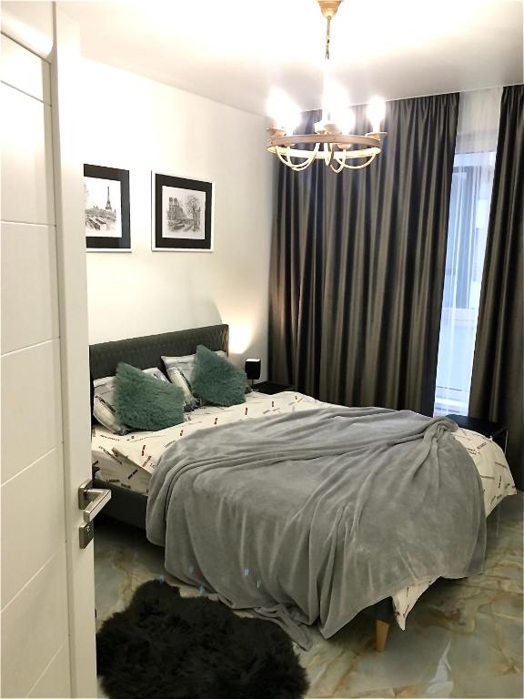 a bedroom with a bed and a chandelier at Modern 3-bedroom jacuzzi apartment in Lviv