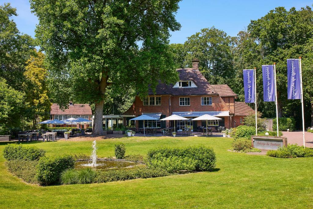 een groot gebouw met blauwe vlaggen in een park bij Auberge Du Bonheur in Tilburg