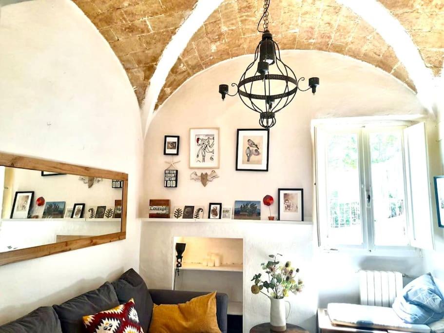 ein Wohnzimmer mit einem Sofa und einem Kronleuchter in der Unterkunft Charming apartment close to the Piazza in Volterra