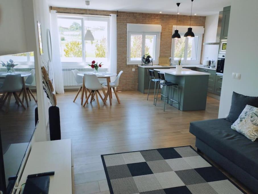 a living room and kitchen with a couch and a table at Precioso apartamento en Pamplona junto al centro in Pamplona