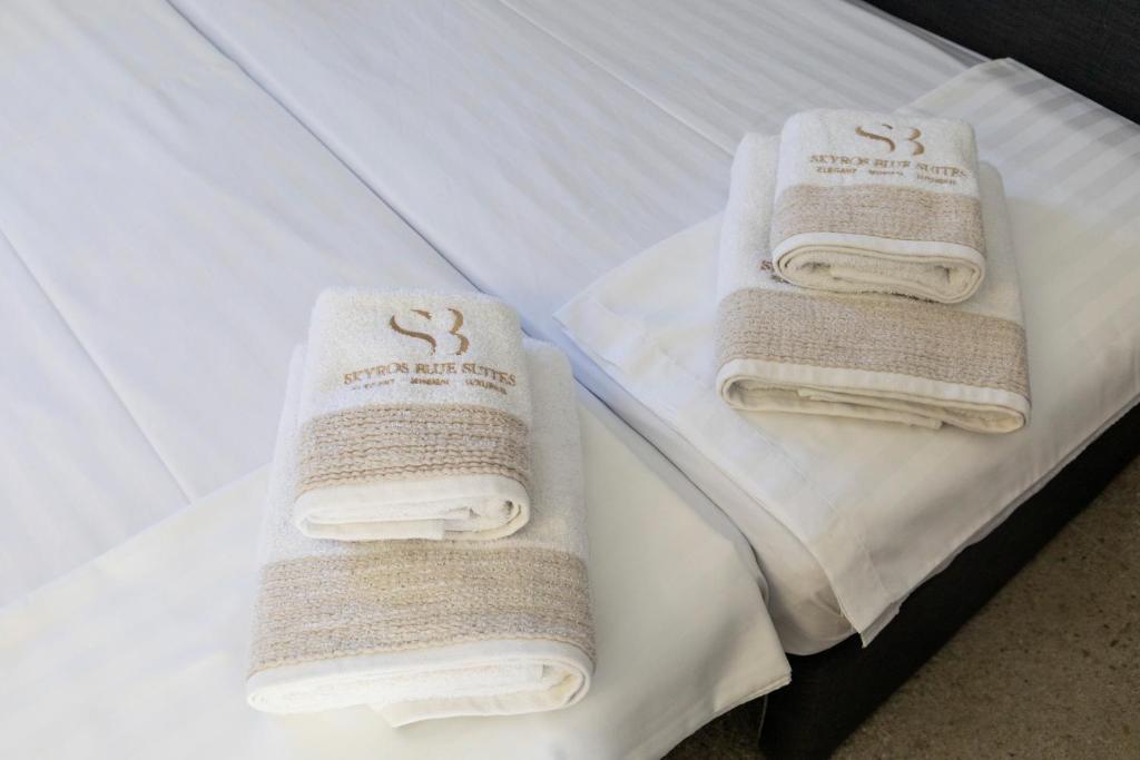 A bed or beds in a room at SKYROS BLUE SUITES
