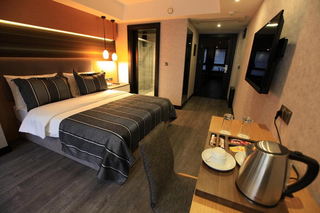 una habitación de hotel con una cama grande y una mesa en The Black Hotel, en Eskisehir