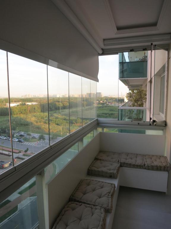 a room with a balcony with a large window at Apartamento luxuoso com infra completa próximo a Praia da Barra da Tijuca in Rio de Janeiro