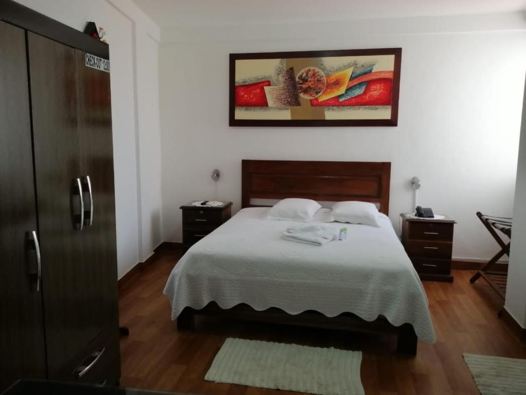 1 dormitorio con 1 cama con 2 toallas en Buen Retiro Apart Hotel, en Santa Cruz de la Sierra