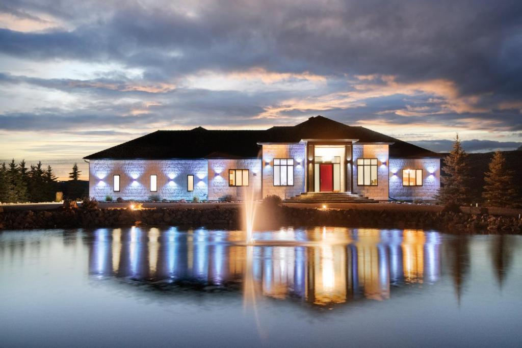 a house with lights on the water at night at Modern Gated 8 Bedroom Mansion Built on 5 Acres in Grainger