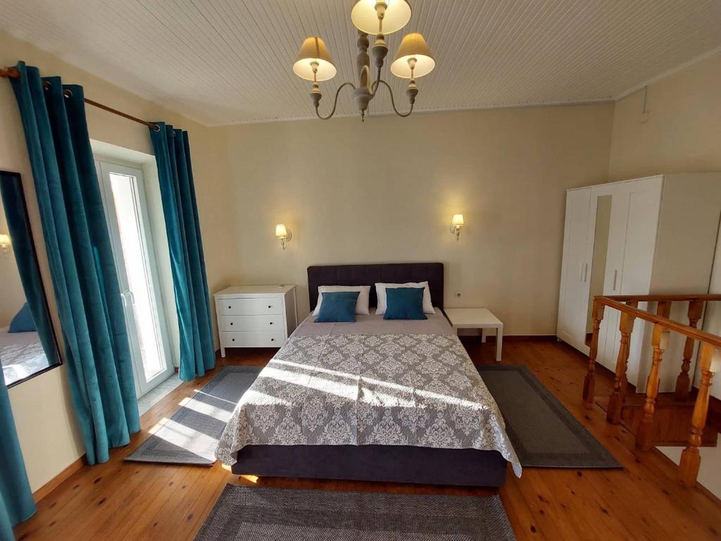 a bedroom with a bed with blue pillows at Alegria House 150m from the beach in Gouvia