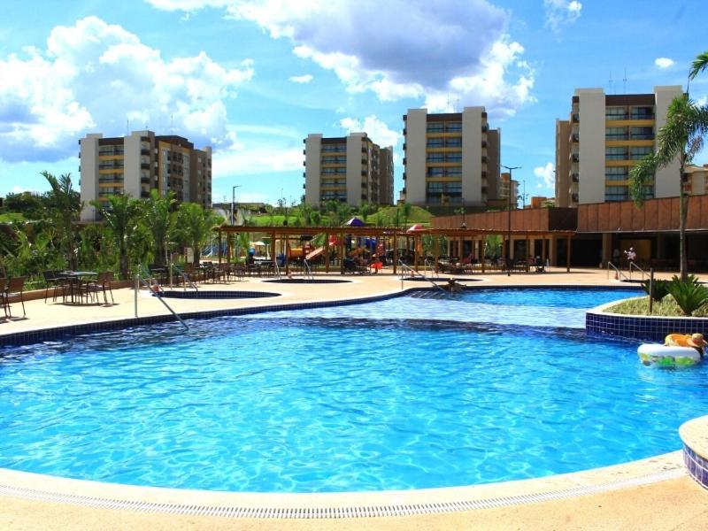 a large swimming pool in a city with tall buildings at Resort Praias do Lago in Caldas Novas