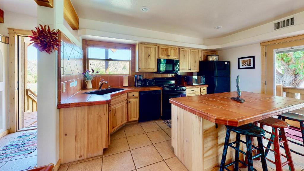 a kitchen with wooden cabinets and a island with a counter top at Pack Creek ~ Orchard House in Moab