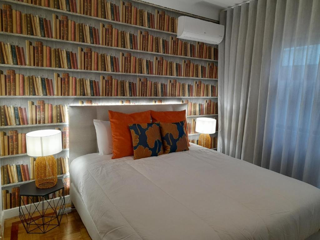 ein Schlafzimmer mit einem Bett und einer Bücherwand in der Unterkunft Cozy Central 3 Bedrooms Bragas in Porto