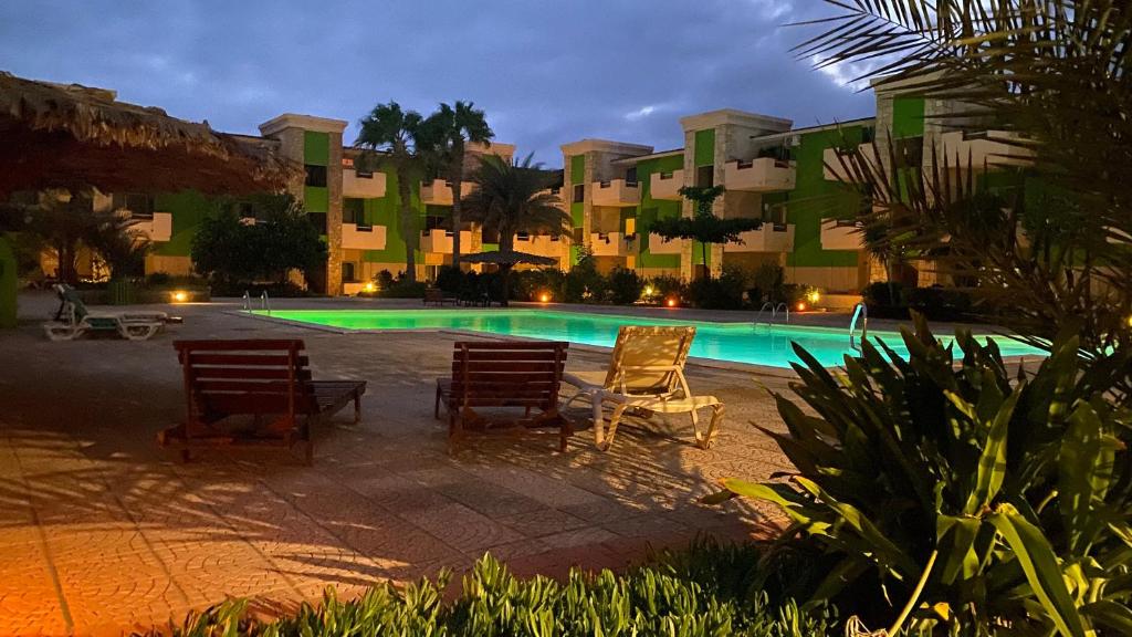 聖瑪麗亞的住宿－Apartamento Moradias，一座带两把椅子的游泳池以及一座建筑