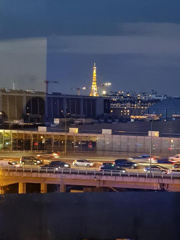 une ville à circulation routière la nuit dans l'établissement APPARTEMENT AVEC VUE SUR LA TOUR EIIFEL, à Issy-les-Moulineaux