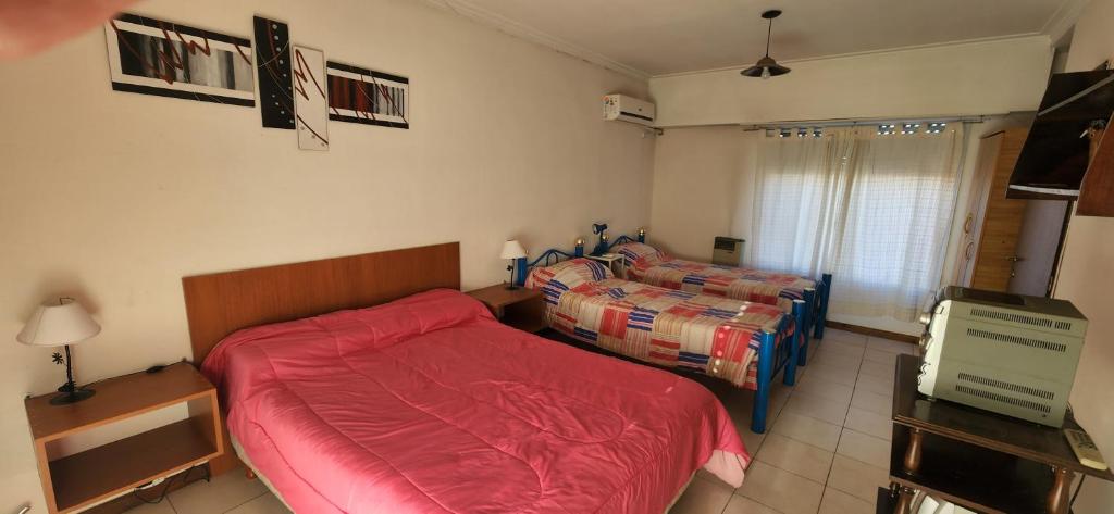 een slaapkamer met 2 bedden en een televisie. bij Depto semicentrico. in Tandil