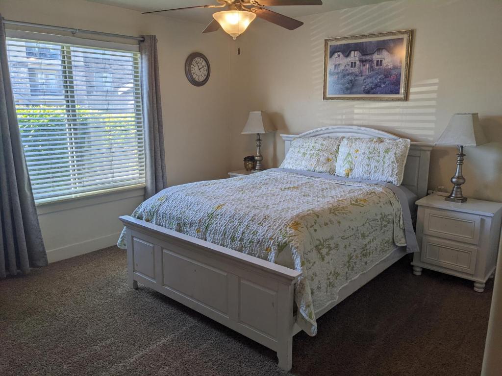 a bedroom with a bed and a fan and a window at The Tuscan Lodge in Payson