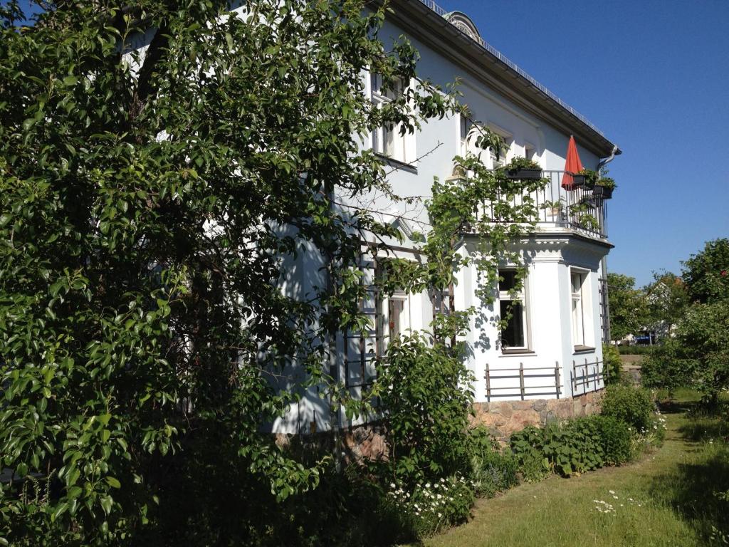 ein weißes Haus mit einer Flagge auf dem Balkon in der Unterkunft Ferienwohnung Fläming in Bad Belzig