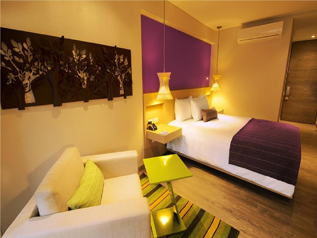 a hotel room with a bed and a couch at Hotel Bari Bucaramanga in Bucaramanga