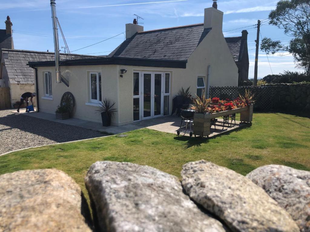a white house with rocks in front of it at Bracken Cottage in Ballymartin